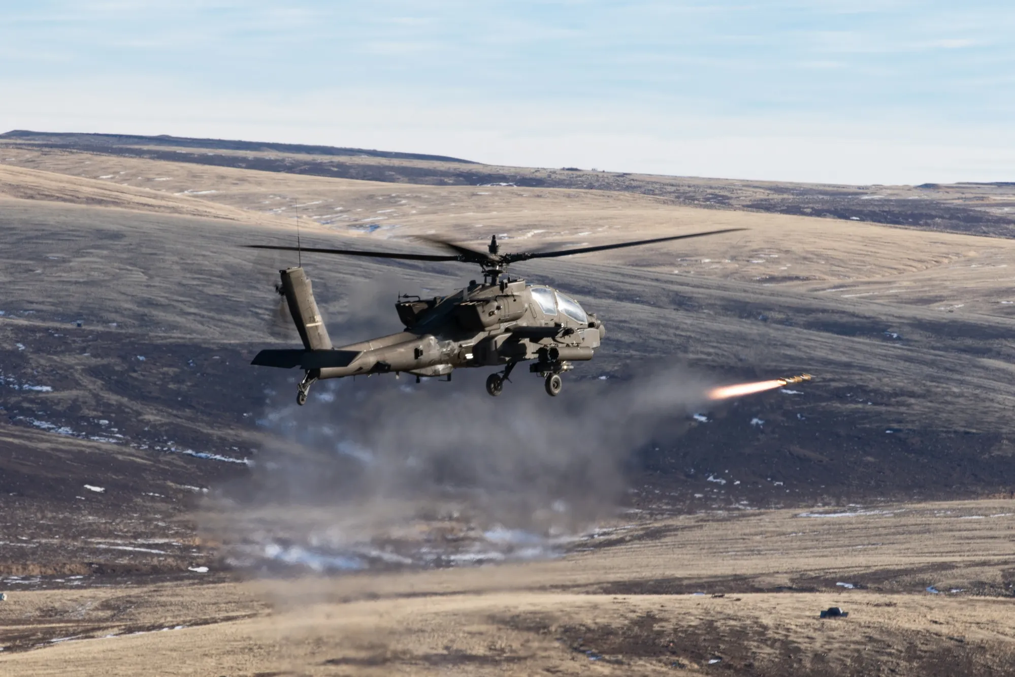 AH-64E Apache firing Hellfire — 3/4 view with smoke trail